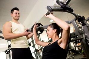 Fitness trainer helping woman
